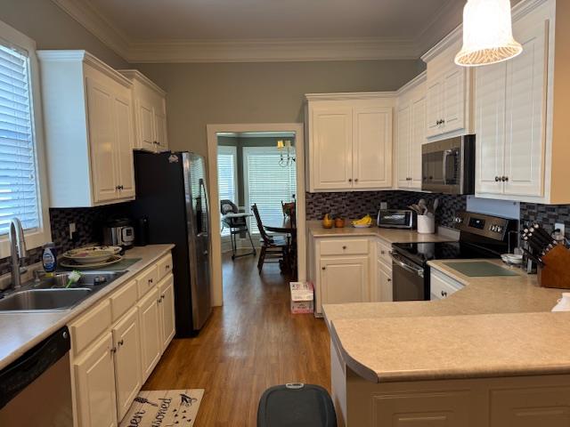 208 Craftsman Dr, Dothan, AL 36303 - kitchen with stainless steel appliances, light wood-style floors, white cabinetry, light countertops, and ornamental molding