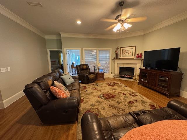 208 Craftsman Dr, Dothan, AL 36303 - living area with wood finished floors, ceiling fan, crown molding, and a fireplace