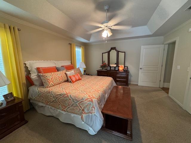 208 Craftsman Dr, Dothan, AL 36303 - carpeted bedroom featuring a raised ceiling, crown molding, multiple windows, and a ceiling fan