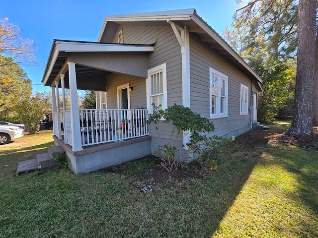 view of property exterior with a porch and a yard