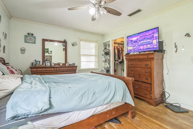 283 E King St, Newton, AL 36352 - bedroom with wood finished floors, crown molding, a spacious closet, a closet, and a ceiling fan