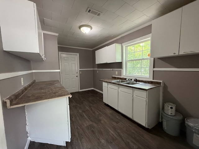 1028 S Bell St, Dothan, AL 36301 - kitchen featuring ornamental molding, a sink, dark wood-type flooring, white cabinetry, and dark countertops