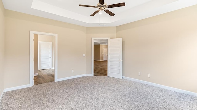 310 Heritage Way, Headland, AL 36345 - unfurnished bedroom with carpet floors, a raised ceiling, a ceiling fan, and baseboards