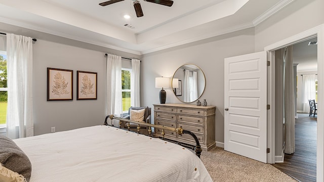 bedroom featuring hardwood / wood-style flooring, multiple windows, ornamental molding, and ceiling fan