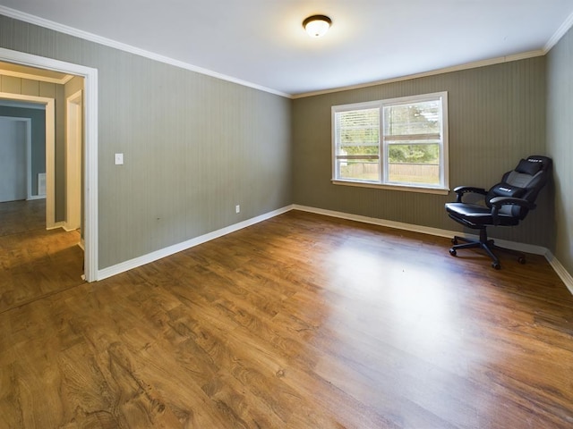 interior space with ornamental molding, wood finished floors, and baseboards