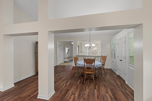 dining space featuring sink, a chandelier, and dark hardwood / wood-style floors