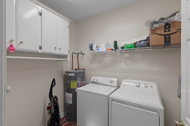 clothes washing area featuring cabinets, washer and clothes dryer, and electric water heater