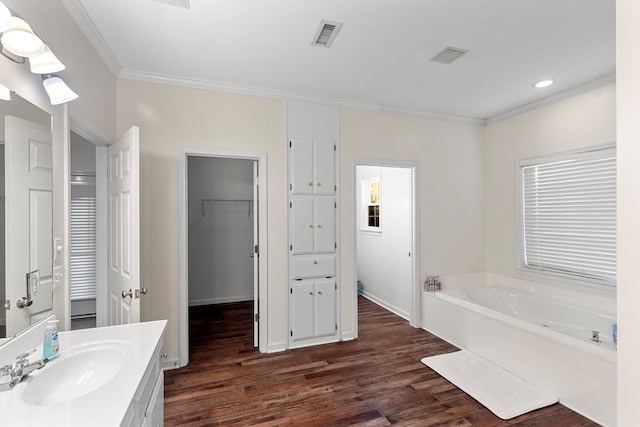 bathroom with ornamental molding, a bathtub, vanity, and hardwood / wood-style flooring