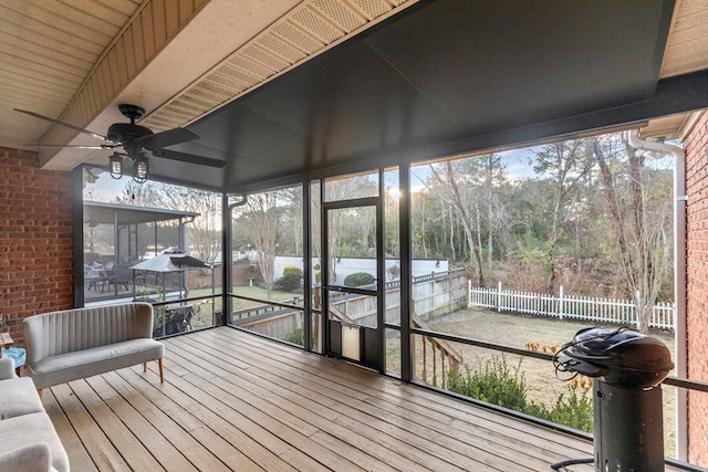 unfurnished sunroom with ceiling fan and beamed ceiling