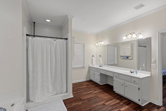 bathroom featuring hardwood / wood-style flooring, crown molding, and vanity