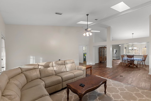 living room featuring ceiling fan with notable chandelier, lofted ceiling with skylight, and dark hardwood / wood-style floors