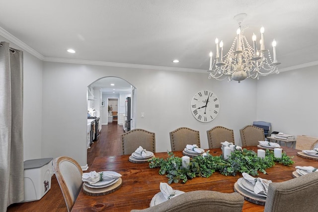 dining space featuring crown molding, dark wood-type flooring, and a chandelier