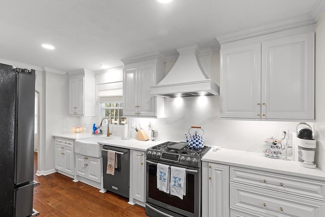 kitchen with premium range hood, sink, appliances with stainless steel finishes, dark hardwood / wood-style flooring, and white cabinetry