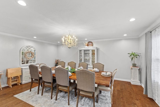 dining room featuring wood-type flooring, crown molding, and a notable chandelier