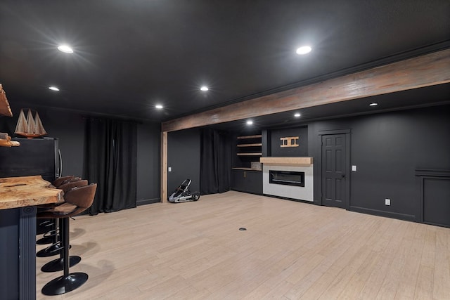 bar featuring black refrigerator and light hardwood / wood-style floors