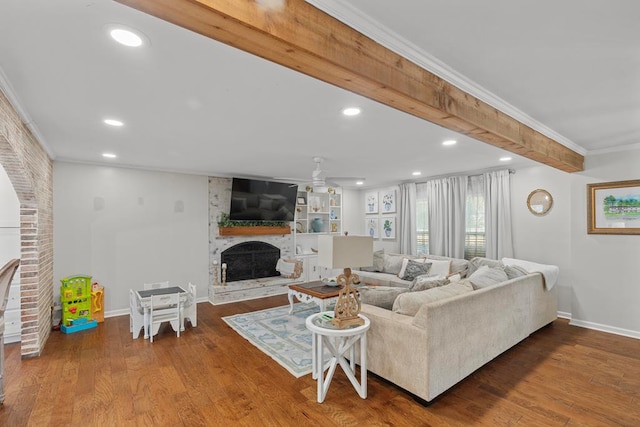 living room featuring crown molding, a fireplace, ceiling fan, and hardwood / wood-style floors