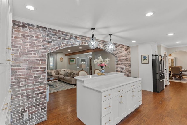 kitchen featuring high quality fridge, brick wall, pendant lighting, white cabinets, and dark hardwood / wood-style floors