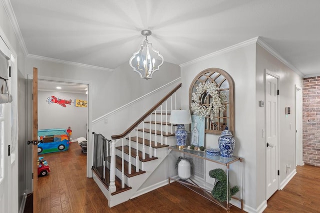 staircase with wood-type flooring, ornamental molding, and a chandelier