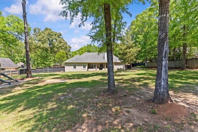 view of yard with a fenced backyard and a playground