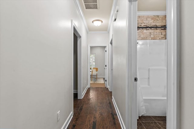 hallway featuring visible vents, dark wood-style floors, and ornamental molding