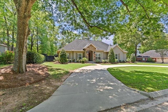 single story home with stucco siding, a front yard, and fence