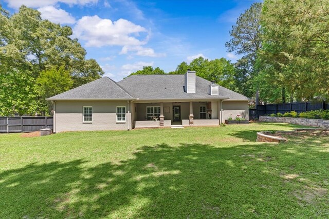back of house with a patio area, a lawn, and a fenced backyard