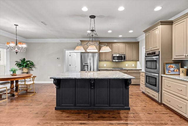 kitchen with a kitchen island with sink, tasteful backsplash, baseboards, a chandelier, and appliances with stainless steel finishes