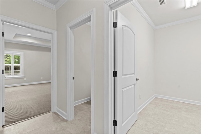 hallway featuring carpet floors, visible vents, baseboards, and ornamental molding