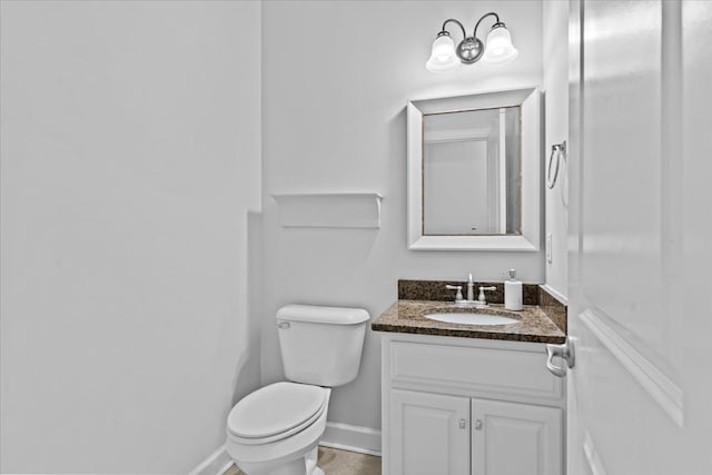 bathroom featuring vanity, toilet, and baseboards