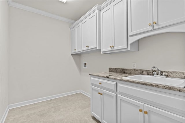 laundry room with a sink, baseboards, cabinet space, washer hookup, and crown molding