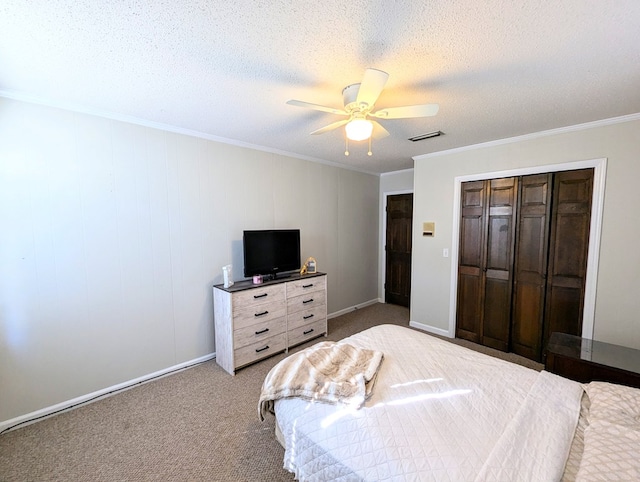 carpeted bedroom featuring ceiling fan, ornamental molding, a textured ceiling, and a closet