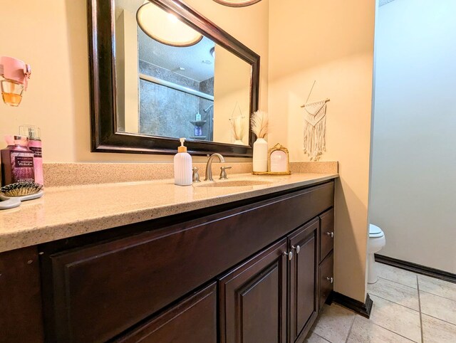 bathroom with tile patterned flooring, vanity, and toilet