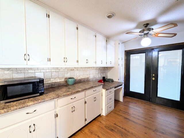 kitchen featuring white cabinets, light hardwood / wood-style flooring, a textured ceiling, appliances with stainless steel finishes, and tasteful backsplash