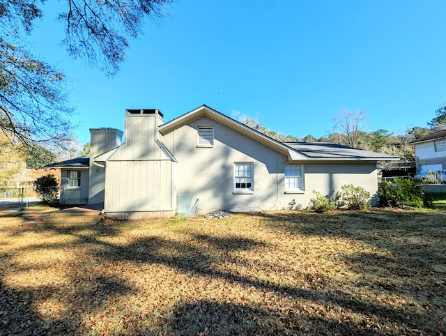 rear view of property featuring a lawn