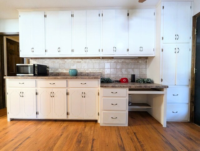 kitchen with decorative backsplash, white cabinetry, and light hardwood / wood-style flooring