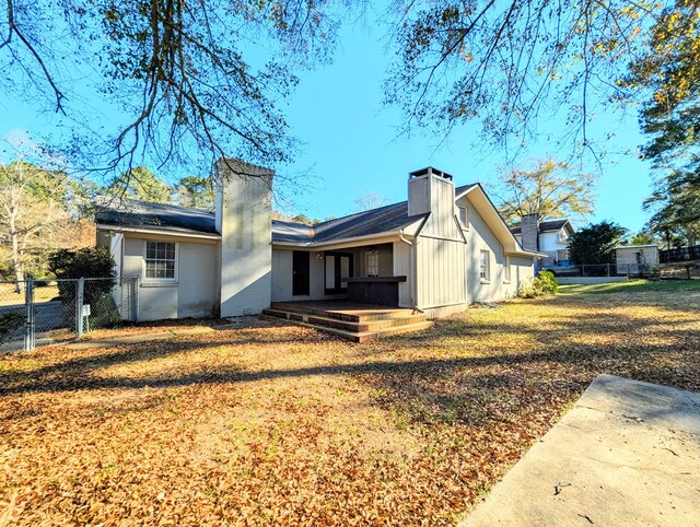 rear view of property with a yard