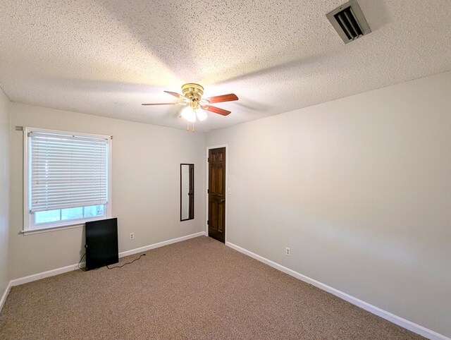 spare room with ceiling fan, carpet floors, and a textured ceiling