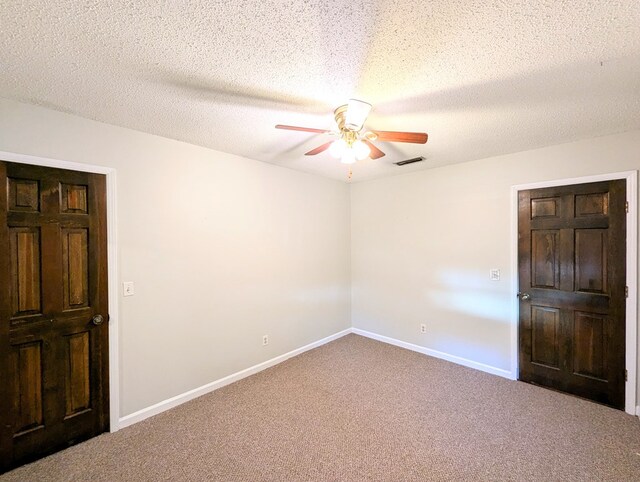 carpeted spare room with a textured ceiling and ceiling fan