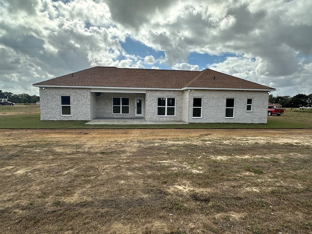 rear view of property with a yard and a patio