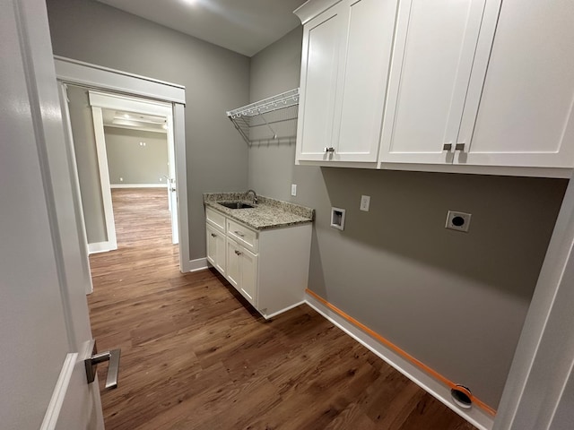 washroom with electric dryer hookup, cabinets, dark wood-type flooring, sink, and washer hookup