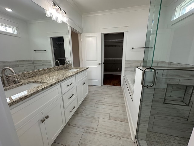 bathroom with vanity, ornamental molding, tile walls, and independent shower and bath