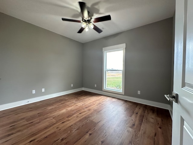 spare room featuring ceiling fan and dark wood-type flooring