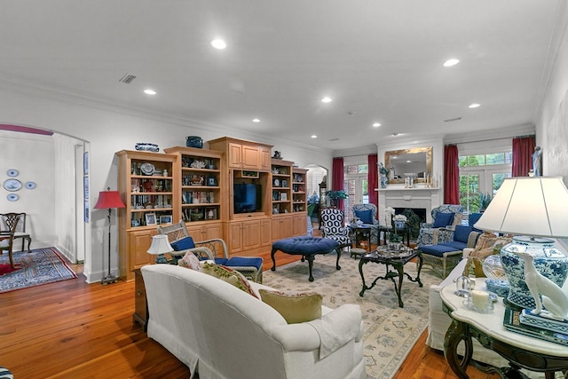 6 Williamsburg Pl, Dothan, AL 36305 - living area featuring ornamental molding, arched walkways, light wood-style floors, a fireplace, and recessed lighting