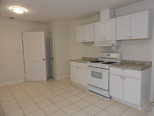 kitchen featuring white gas range, white cabinetry, range hood, and crown molding