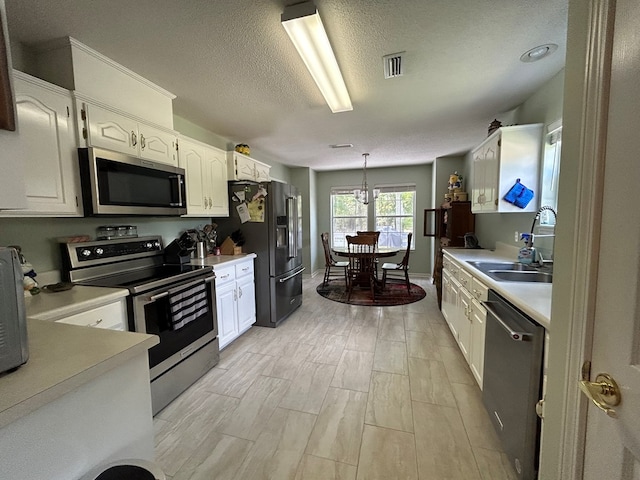 123 Waterford Way, Ashford, AL 36321 - kitchen with appliances with stainless steel finishes, a sink, white cabinets, light countertops, and light wood-style flooring