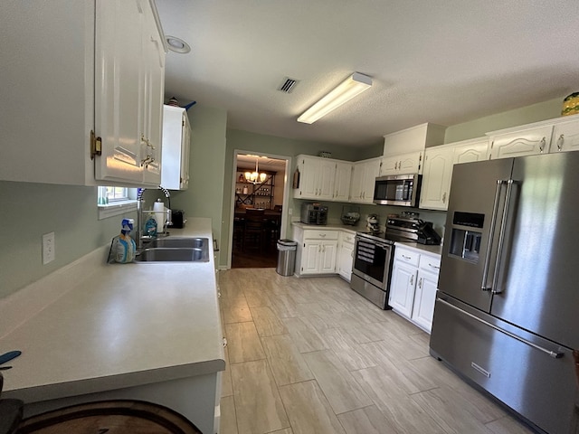 123 Waterford Way, Ashford, AL 36321 - kitchen featuring stainless steel appliances, a chandelier, a sink, white cabinets, and light countertops