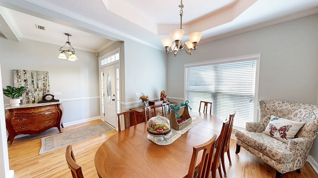 218 Azalea Ln, Headland, AL 36345 - dining room with a chandelier, wood finished floors, ornamental molding, a tray ceiling, and baseboards
