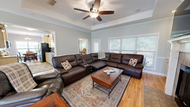 218 Azalea Ln, Headland, AL 36345 - living area featuring a raised ceiling, a tile fireplace, a ceiling fan, light wood-style floors, and baseboards
