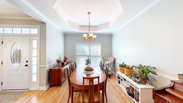 218 Azalea Ln, Headland, AL 36345 - dining room with light wood-style flooring, a chandelier, a raised ceiling, and baseboards