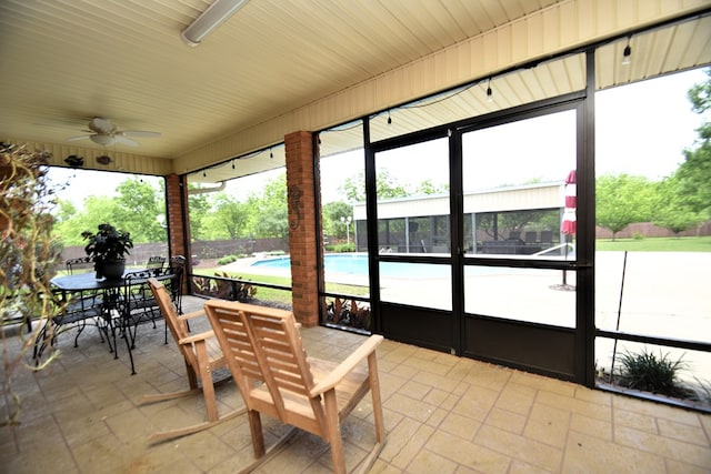 sunroom / solarium with a ceiling fan and outdoor dining space
